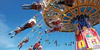 A carnival ride with many rides and balloons.